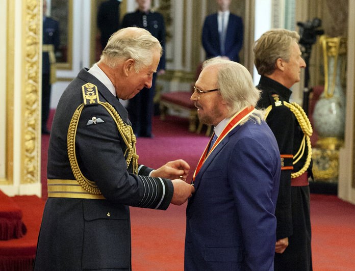 Singer and songwriter Barry Gibb talks with Prince Charlesm (left) during an Investiture ceremony to award a knighthood to Gibb, at Buckingham Palace in London, Tuesday June 26. (Dominic Lipinski/PA via AP)