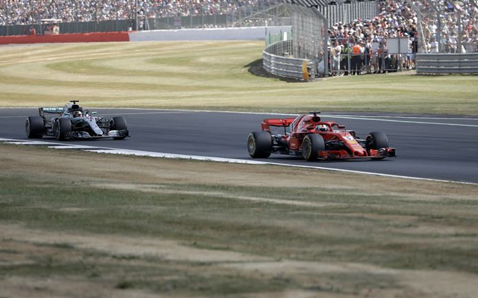 Ferrari driver Sebastian Vettel of Germany, right, steers his car followed by Mercedes driver Lewis Hamilton of Britain during the British Formula One Grand Prix at the Silverstone racetrack, Silverstone, England, Sunday, July 8, 2018. (AP Photo/Luca Bruno)