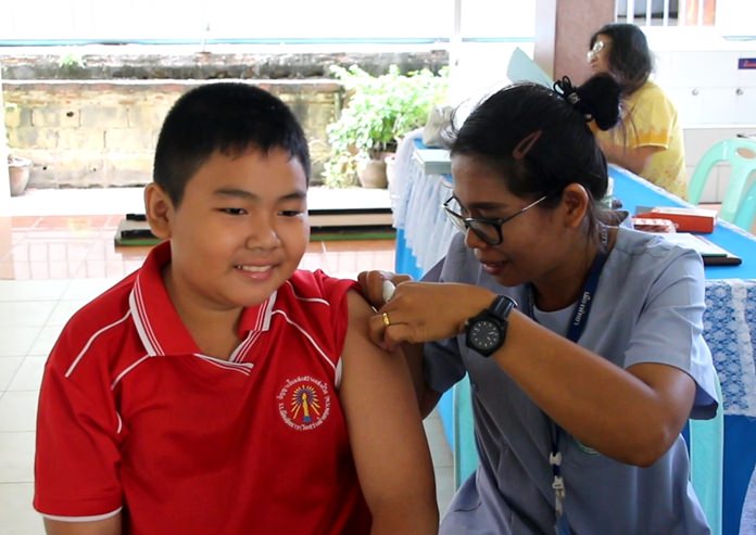 A brave student from Pattaya School No. 3 takes his diphtheria and tetanus vaccination shots with a smile.