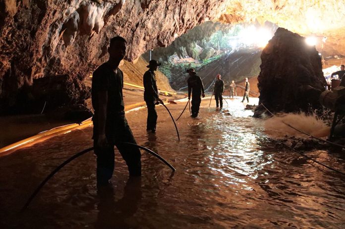 Thai rescue teams arrange the water pumping system at the entrance to the flooded cave complex on 7 July. (Royal Thai Navy via AP)