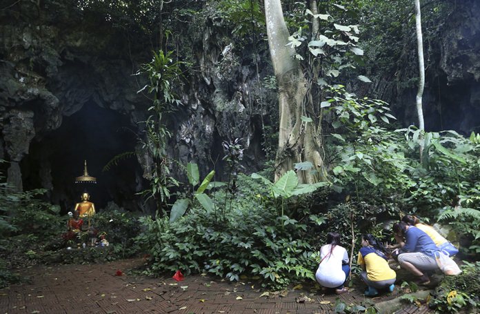 Family members pray in front of a Buddhist statue near the cave July 7, where 12 boys and their soccer coach have been trapped since June 23. (AP Photo/Sakchai Lalit)