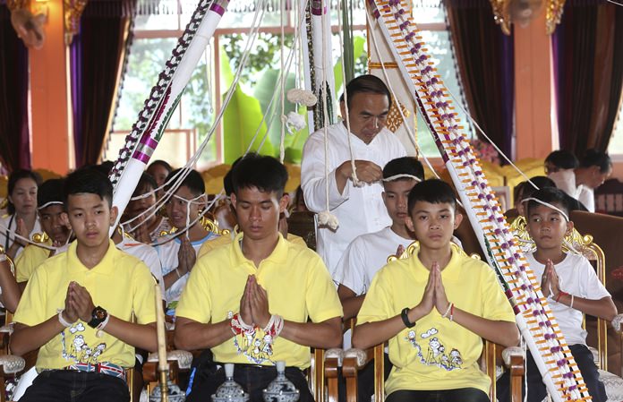 Soccer coach Ekkapol Janthawong, second from left, and members of the rescued soccer team attend a Buddhist ceremony in Mae Sai district, Chiang Rai province, Thursday, July 19. (AP Photo/Sakchai Lalit)