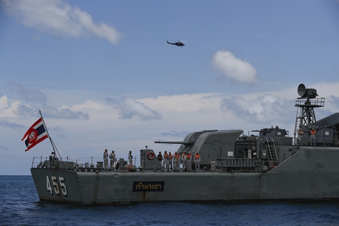 A helicopter and a Thai navy vessel search for missing passengers from a capsized tourist boat in the water off Phuket, Saturday, July 7. (AP Photo/Vincent Thian)