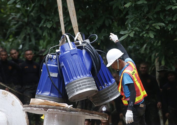 Pumps are moved from truck to be used to help drain the rising flood water in a cave where 12 boys and their soccer coach have been trapped since June 23, in Mae Sai, Chiang Rai province, in northern Thailand Friday, July 6, 2018. (AP Photo/Sakchai Lalit)