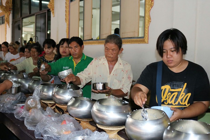 Believers perform a Tak Bat ceremony at Wat Suttawas on Asalaha Bucha Day.