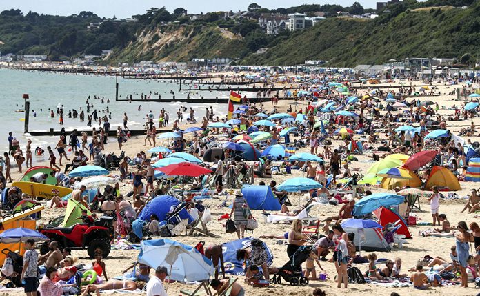 People enjoy the Bournemouth beach in Dorset, England, as the hot weather continues across Britain. (Andrew Matthews/PA via AP)