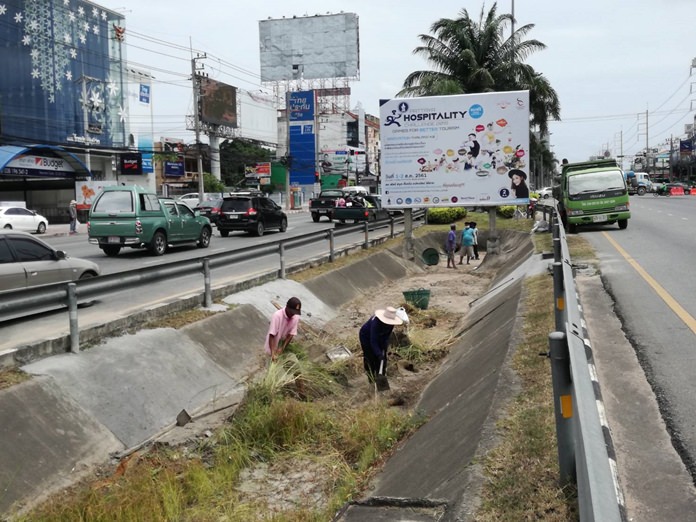 A work crew on Aug. 1 scooped out garbage blocking sewers, sucked out pipes and repaired broken grates in the Sukhumvit median near North Road. They also cut back grass blocking water flow.