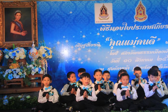 A portrait of HM Queen Sirikit of the Ninth Reign looks over their shoulders as students from Pattaya City Schools sing “Value of Mother’s milk” and “Im Oun” at Central Festival Pattaya Beach.