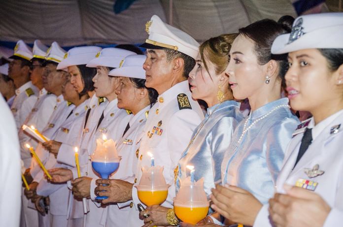 Public officials take part in a candlelight ceremony and sing songs for the Queen in front of Banglamung District Office.
