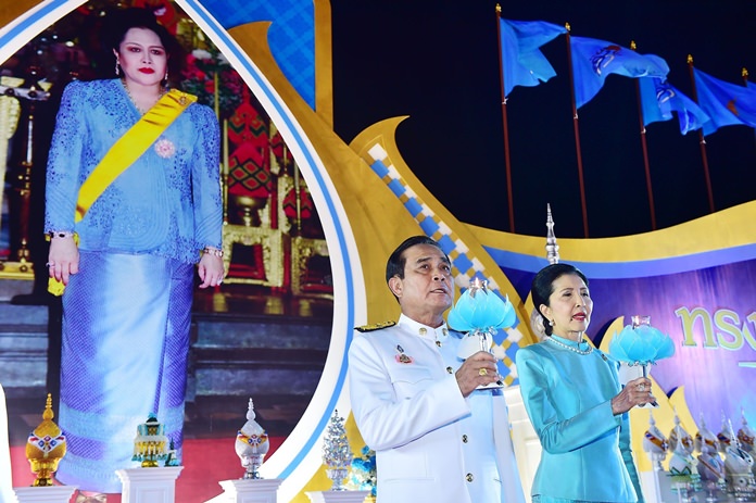 Prime Minister Gen Prayut Chan-ocha and his wife Napaporn light ceremonial candles and sing the royal anthem at Sanam Luang August 12 before chanting “Long Live the Queen” three times. The PM led members of his Cabinet in giving alms to mark the birthday anniversary of Her Majesty Queen Sirikit of the Ninth Reign. (NNT Photo)