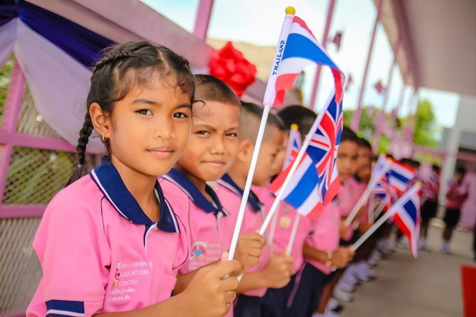 Migrant children at the Drop-in ASEAN Education Center wave British and Thai flags to welcome H.E. British Ambassador Brian Davidson.