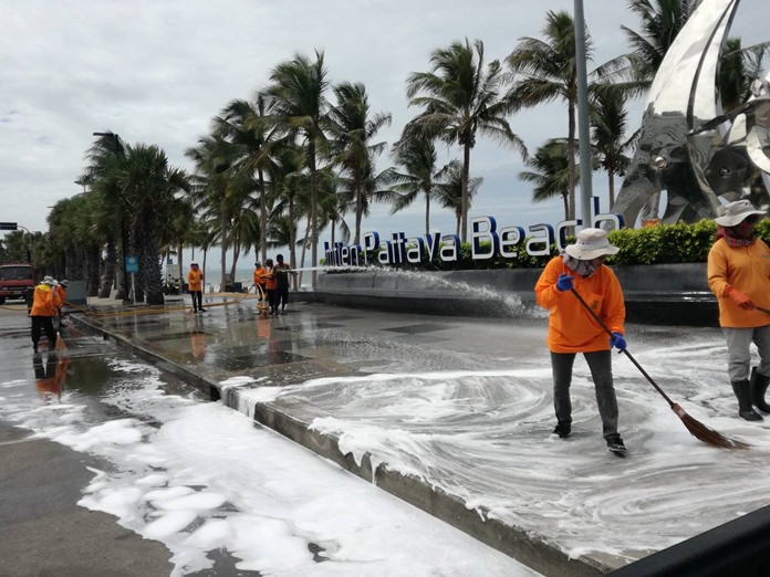 Pattaya sanitation workers clean up Jomtien Beach Road which stank of garbage-scented storm runoff.
