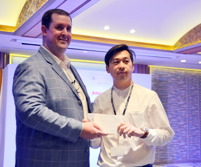 Simon Angove GM of the Pullman Pattaya Hotel G presents a draw prize to the lucky winner.