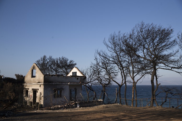 A destroyed house stand near the sea one month after a deadly wildfire tore through holiday homes near Athens, on at the seaside area of Mati. Authorities are still investigating the cause of the fire that killed more than 90 people and touched off a political spat that forced country’s minister of public order to resign. (AP Photo/Petros Giannakouris)