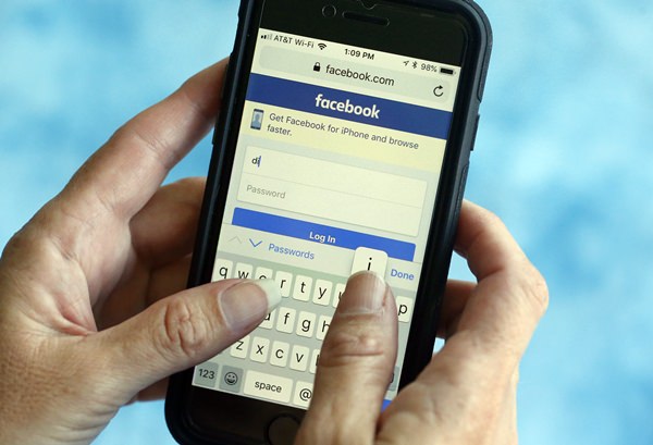 In this file photo dated Tuesday, Aug. 21, 2018, a Facebook start page is shown on a smartphone in Surfside, Fla. USA. The social media giant Facebook said late Wednesday Aug. 22, 2018, it has banned a quiz app for refusing to be audited and concerns that data on as many as 4 million users was misused, after it found user information was shared with researchers and companies. (AP Photo/Wilfredo Lee, FILE)