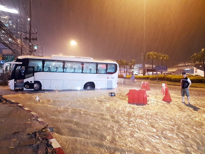 A Lotte Thailand Co. tour bus plunged into an open trench on Soi Photisan near Sukhumvit Road after raging storm runoff ironically washed away barriers erected by crews installing new flood-control pipes.