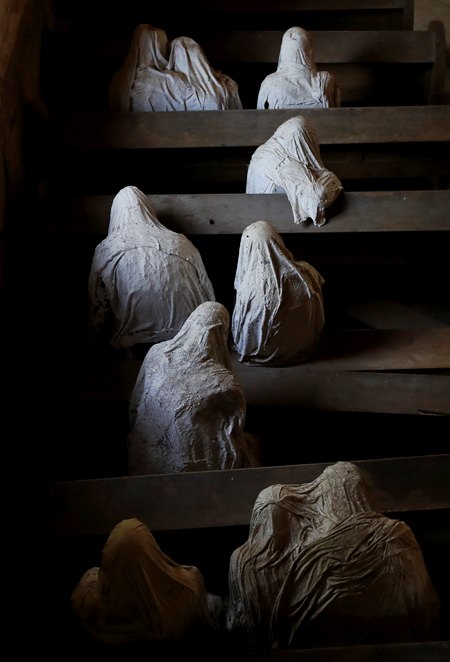 Ghostly figures sit in pews at the church of Saint George. (AP Photo/Petr David Josek)