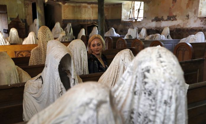 A French tourist visits the church. In 2012, art student Jakub Hadrava filled the church’s pews with ghostly figures made from plaster casts of live models draped in white cloth. The effect is chilling. He called the work ‘My Mind’. (AP Photo/Petr David Josek)
