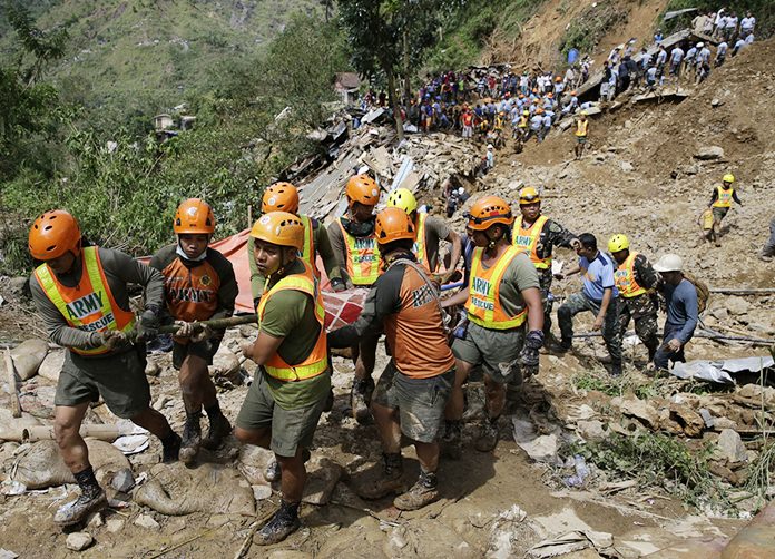Rescuers carry a body recovered from a landslide caused by Typhoon Mangkhut in Itogon, Benguet province, northern Philippines on Monday, Sept. 17. Itogon Mayor Victorio Palangdan said that at the height of the typhoon’s onslaught Saturday afternoon, dozens of people, mostly miners and their families, rushed into an old three-story building in the village of Ucab. The building, a former mining bunkhouse that had been transformed into a chapel, was obliterated when part of a mountain slope collapsed. (AP Photo/Aaron Favila)
