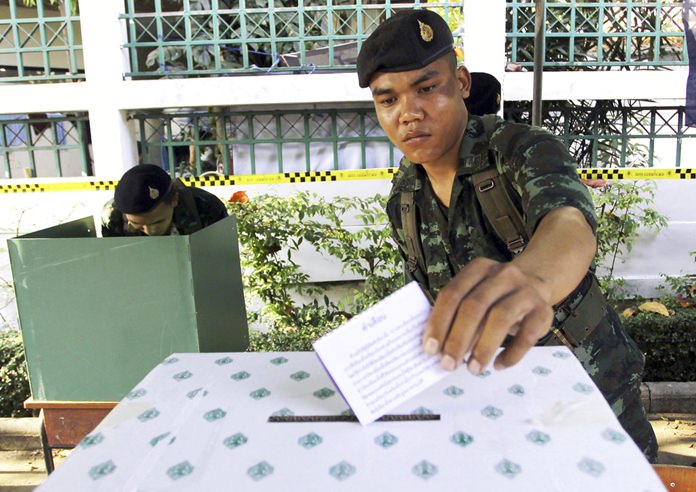 In this Feb. 2, 2014, file photo, a Thai soldier casts his vote during the general election at a polling station in Bangkok, Thailand. Thailand has taken another step toward holding elections next year in 2019 by easing some restrictions on political activities to allow parties to conduct basic functions, but they are still barred from campaigning. (AP Photo/Apichart Weerawong, File)