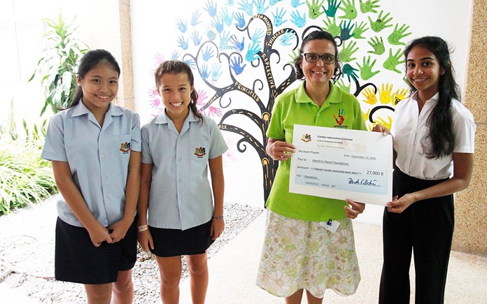 GIS students present a cheque to Ms Margie from the Hand to Hand Foundation in Pattaya.