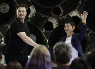 SpaceX founder and chief executive Elon Musk, left, shakes hands with Japanese billionaire Yusaku Maezawa, right, after announcing him as the first private passenger on a trip around the moon, in Hawthorne, Calif. (AP Photo/Chris Carlson)
