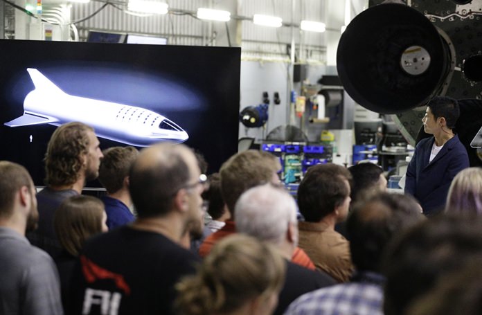 Japanese billionaire Yusaku Maezawa, right, looks at a monitor showing the BFR spacecraft. (AP Photo/Chris Carlson)