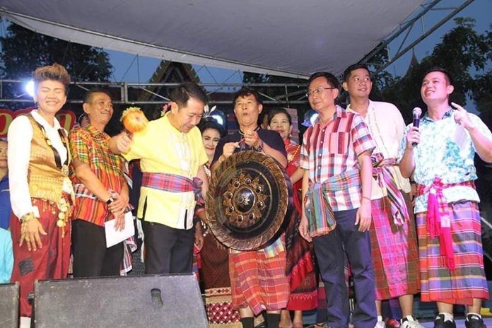 Banglamung District Chief Naris Niramaiwong strikes the gong to begin the festivities as Amnat Theingtham, President of Pattaya Issan Association and other honored guests look on.
