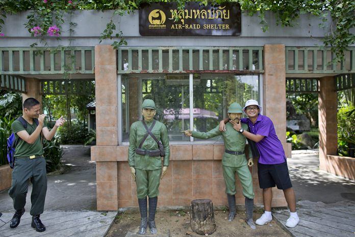 A man poses for a photo at the entrance to an old air-raid shelter, at the Dusit Zoo in Bangkok. (AP Photo/Gemunu Amarasinghe)