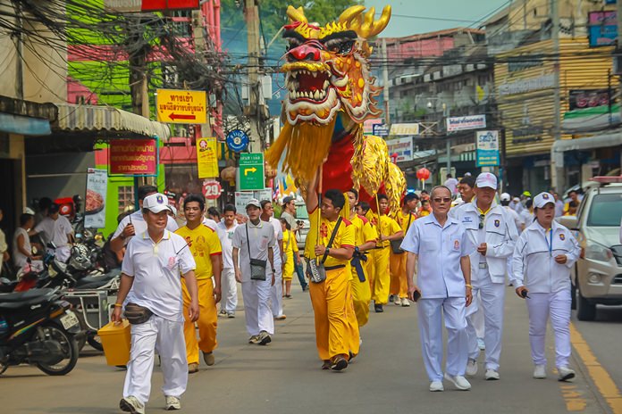 Sawang Boriboon Thammasathan Foundation President Wisit Chaowalitnittithum leads the dragon and lion parade through Naklua streets,