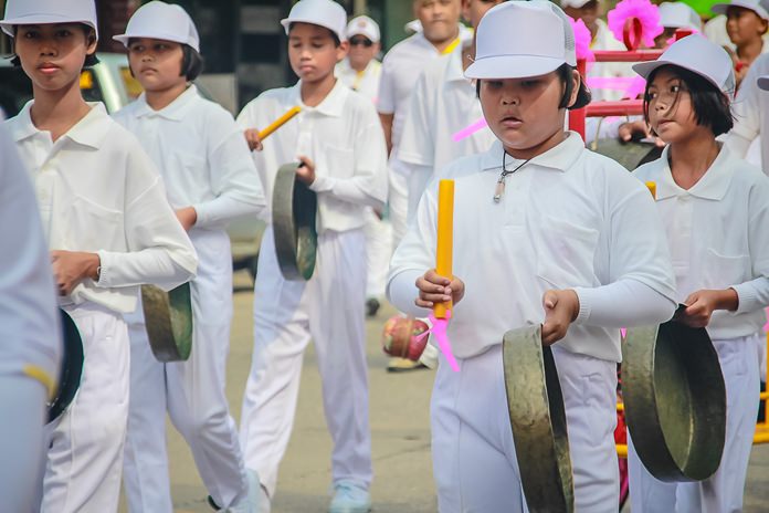 Youths wearing white join the parade.