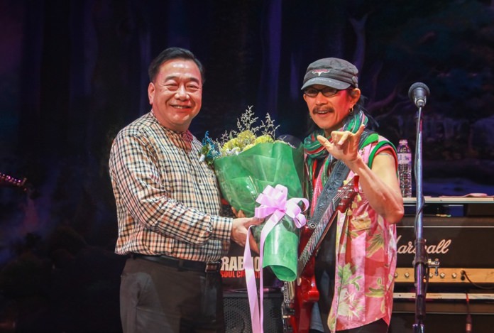 Chonburi Deputy Gov. Phawat Lertmukhda presents a bouquet of thanks to lead singer Ad Carabao.