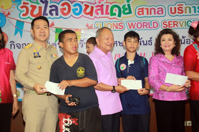 Banglamung District Chief Naris Niramaiwong and Nongprue Mayor Mai Chaiyanit present donated funds to poor families with special needs children.