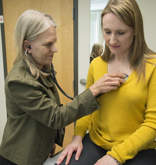 In this 2016 photo provided by the University of Washington, Dr. Linda Vorvick examines Heather VanDusen at UW Neighborhood Clinic in Seattle. When emergency tests showed the telltale right-sided pain in VanDusen’s abdomen was appendicitis, she figured she’d be quickly wheeled into surgery. But doctors offered her the option of antibiotics instead. (Clare McLean/UW Medicine via AP)