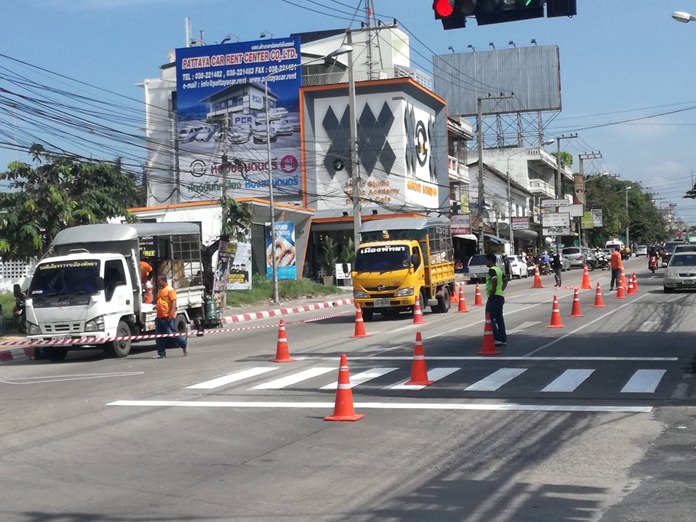 Workers prepare to repaint red-and-white “no parking” zones on curbs and the pedestrian crosswalk on Third Road near Soi Paniadchang.