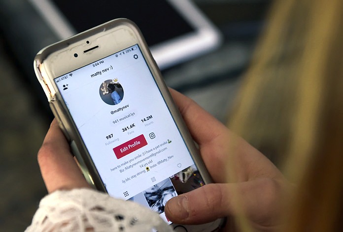 Matty Nev Luby holds her phone and logs into the lip-sync smartphone app Musical.ly, in Wethersfield, Conn. Luby said she's learned to navigate Instagram and other social media apps by brushing aside the anonymous bullies. (AP Photo/Jessica Hill)