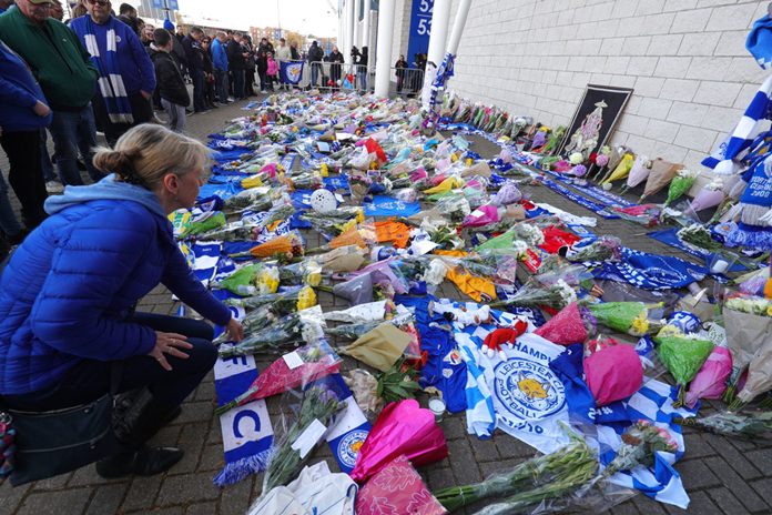 Supporters pay tribute outside Leicester City Football Club after a helicopter crashed in flames the previous day, in Leicester, England, Sunday, Oct. 28, 2018. (Aaron Chown/PA via AP)