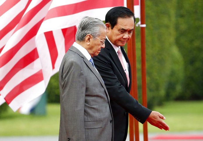 Malaysian Prime Minister Mahathir Mohamad, front, is shown the way by Thailand's Prime Minister Prayuth Chan-ocha during a welcoming ceremony at the government house in Bangkok, Wednesday, Oct. 24. (AP Photo/Sakchai Lalit, Pool)