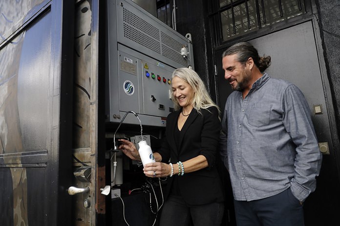 The Skysource/Skywater Alliance co-founders David Hertz, right, and his wife Laura Doss-Hertz demonstrate how the Skywater 300 works Wednesday, Oct. 24, 2018, in Los Angeles. The company received the $1.5 million XPrize For Water Abundance for developing the Skywater 300, a machine that makes water from air. (AP Photo/Marcio Jose Sanchez)