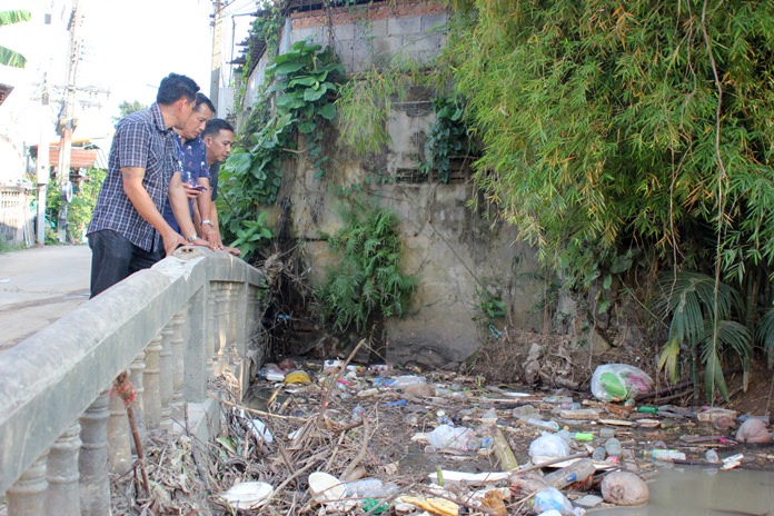 Deputy City Manager Passakorn Usomboon and Sanitation Department workers survey the Kratinglai Canal at Paisan village.