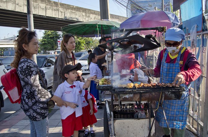School children gather around street vendors outside their school in Bangkok. (AP Photo/Gemunu Amarasinghe 18/11/1)