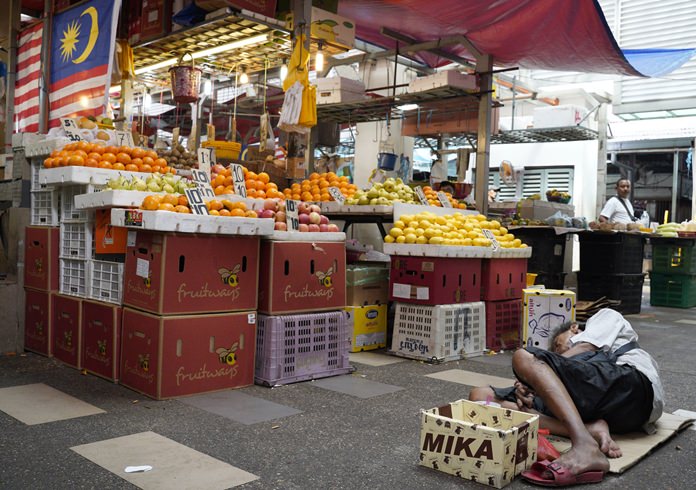 3. A homeless man sleeps on the floor of a wet market in Kampung Baru, Malaysia. (AP Photo/Yam G-Jun 18/11/1)