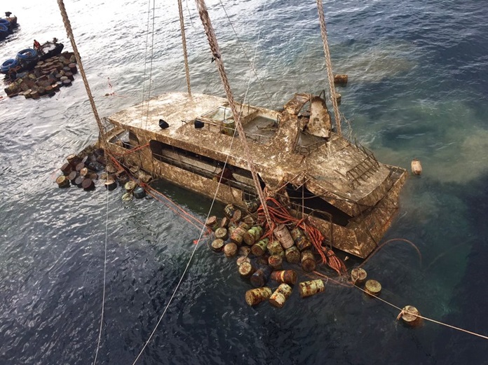 In this photo taken and released by the Thailand Phuket Public Affairs Office, Saturday, Nov. 17, the tour boat named the Pheonix is raised from the sea floor after sinking over four months ago in rough weather killing 47 tourists. (Phuket Public Affairs Office via AP)
