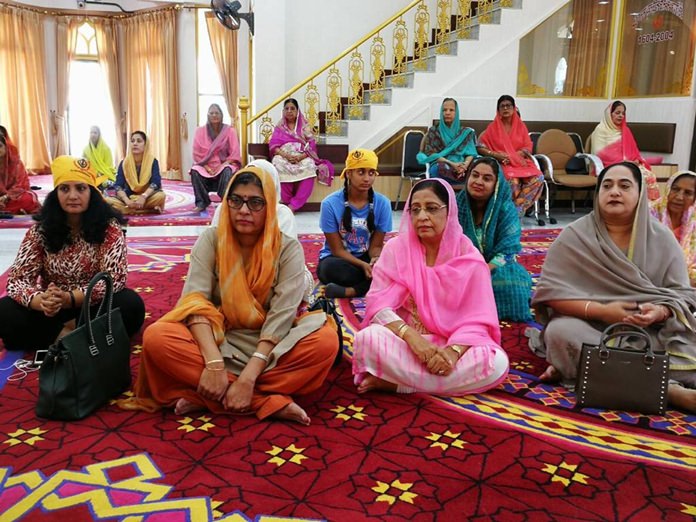 H.E. Mrs. Suchitra Durai joins the congregation in prayer and listening to holy verses from the Guru Granth sahib.