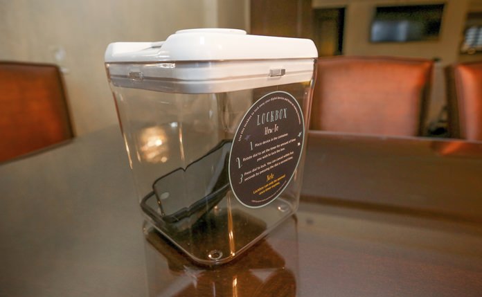 This Dec. 1, 2018 photo shows a locked box holding cell phones during a digital detox visit to the Wyndham Grand Hotel in Chicago. A growing number of hotels are helping guests take a vacation from their vacation by offering incentives to guests willing to lock up their cell phones. (AP Photo/Teresa Crawford)