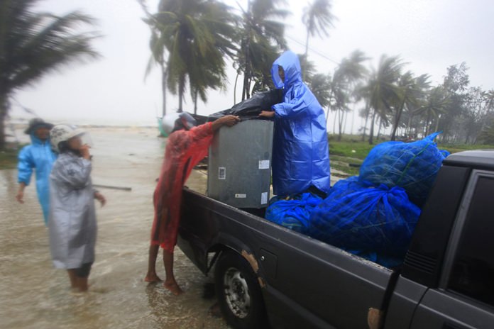 Locals clear out supplies from the coastline in preparation for the approaching Tropical Storm Pabuk, Friday, Jan. 4, in Pak Phanang, Nakhon Si Thammarat. (AP Photo/Sumeth Panpetch)