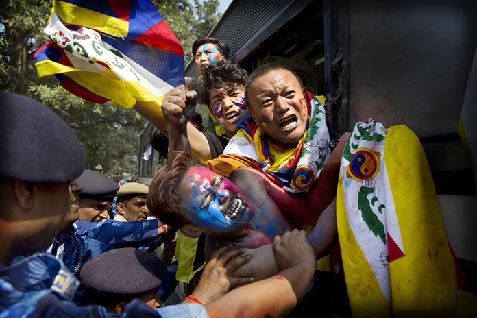 Indian para-military force soldiers push exiled Tibetan activists into a police bus during a protest outside the Chinese Embassy, in New Delhi, India, on March 9, 2018. (AP Photo/Manish Swarup)