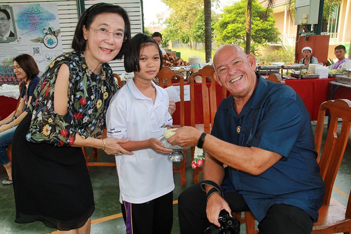 HHNFT Director Radchada Chomjinda and a beautiful young lady present a flower garland to say thanks to Rotarian Rodney Charman.
