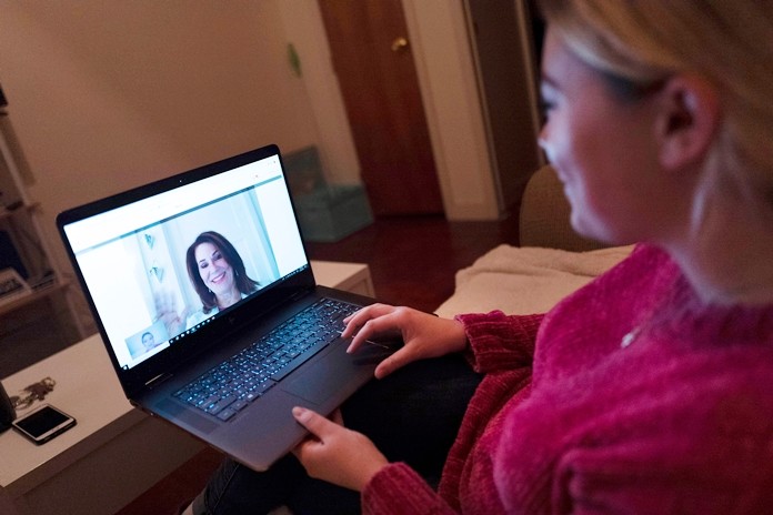 Caitlin Powers sits in the living room of her Brooklyn apartment in New York, and has a telemedicine video conference with physician, Dr. Deborah Mulligan. (AP Photo/Mark Lennihan)