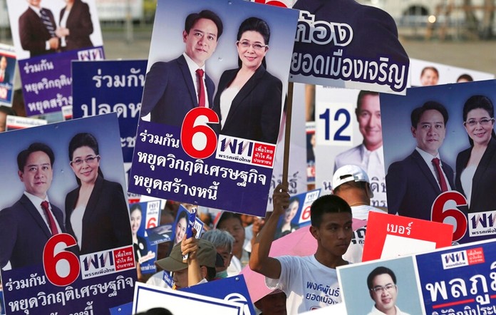 Supporters raise posters of candidates of Pheu Thai Party during an election campaign in Bangkok, Friday, Feb. 15. (AP Photo/Sakchai Lalit)